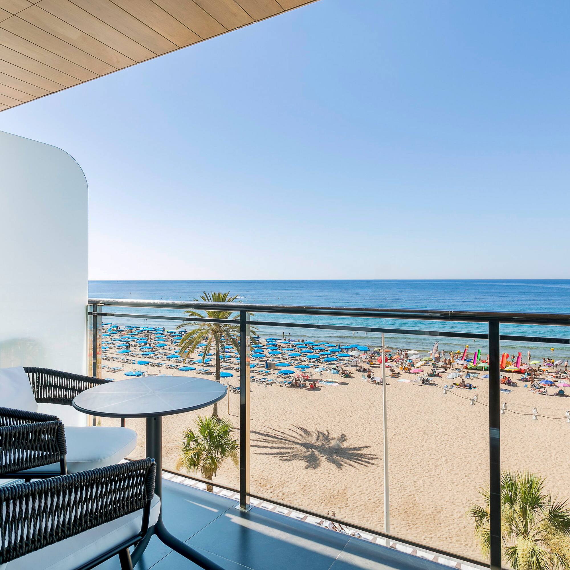a balcony with a beach and a view of the ocean