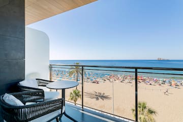 a balcony with a beach and a view of the ocean