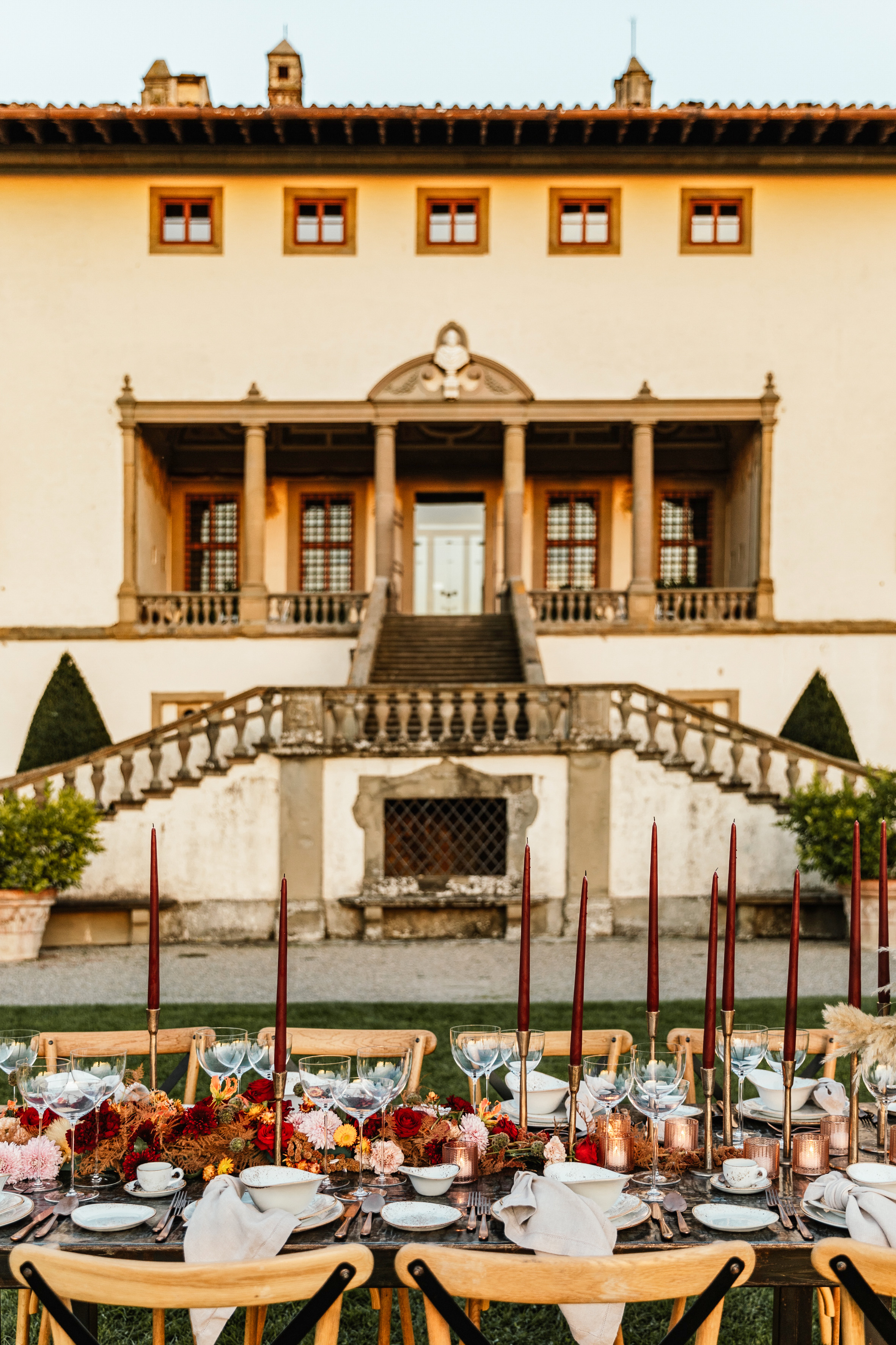 Outdoor wedding reception table with candles, fall florals, historic villa.