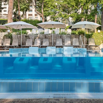 a pool with chairs and umbrellas