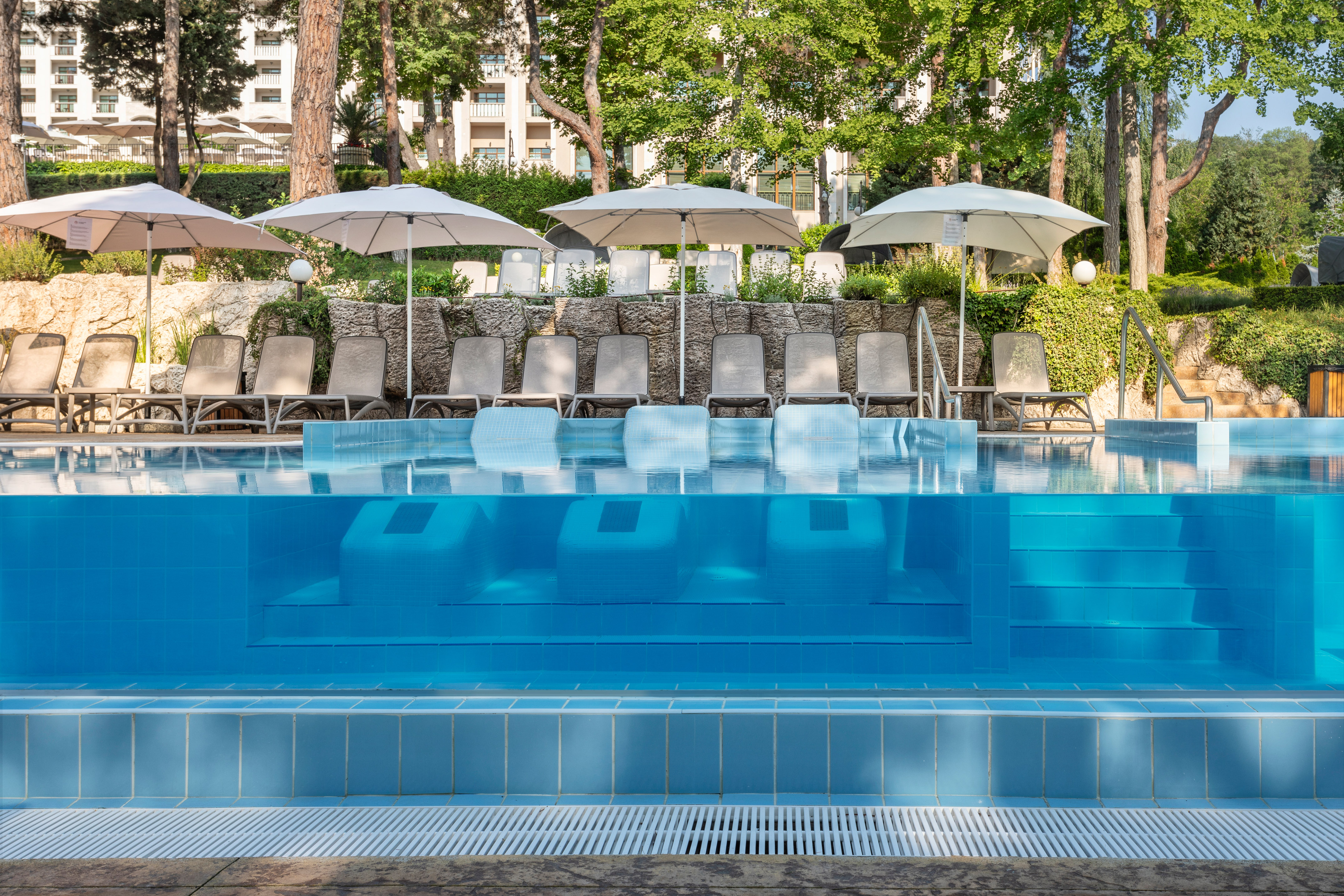 a pool with chairs and umbrellas