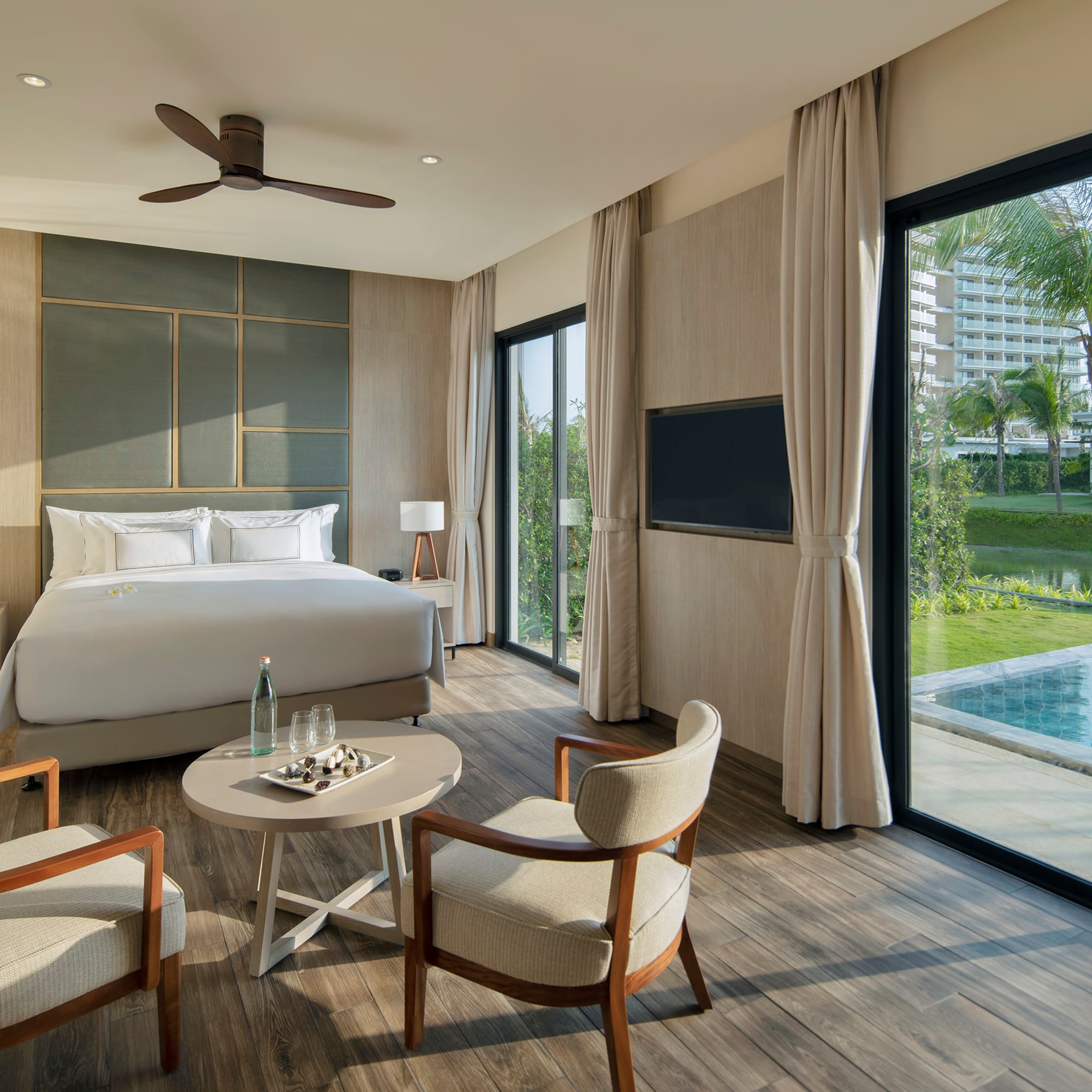 Luxury resort bedroom with private plunge pool, king bed, and tropical view.