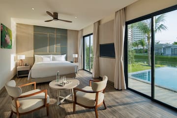 a room with a bed and chairs and a pool