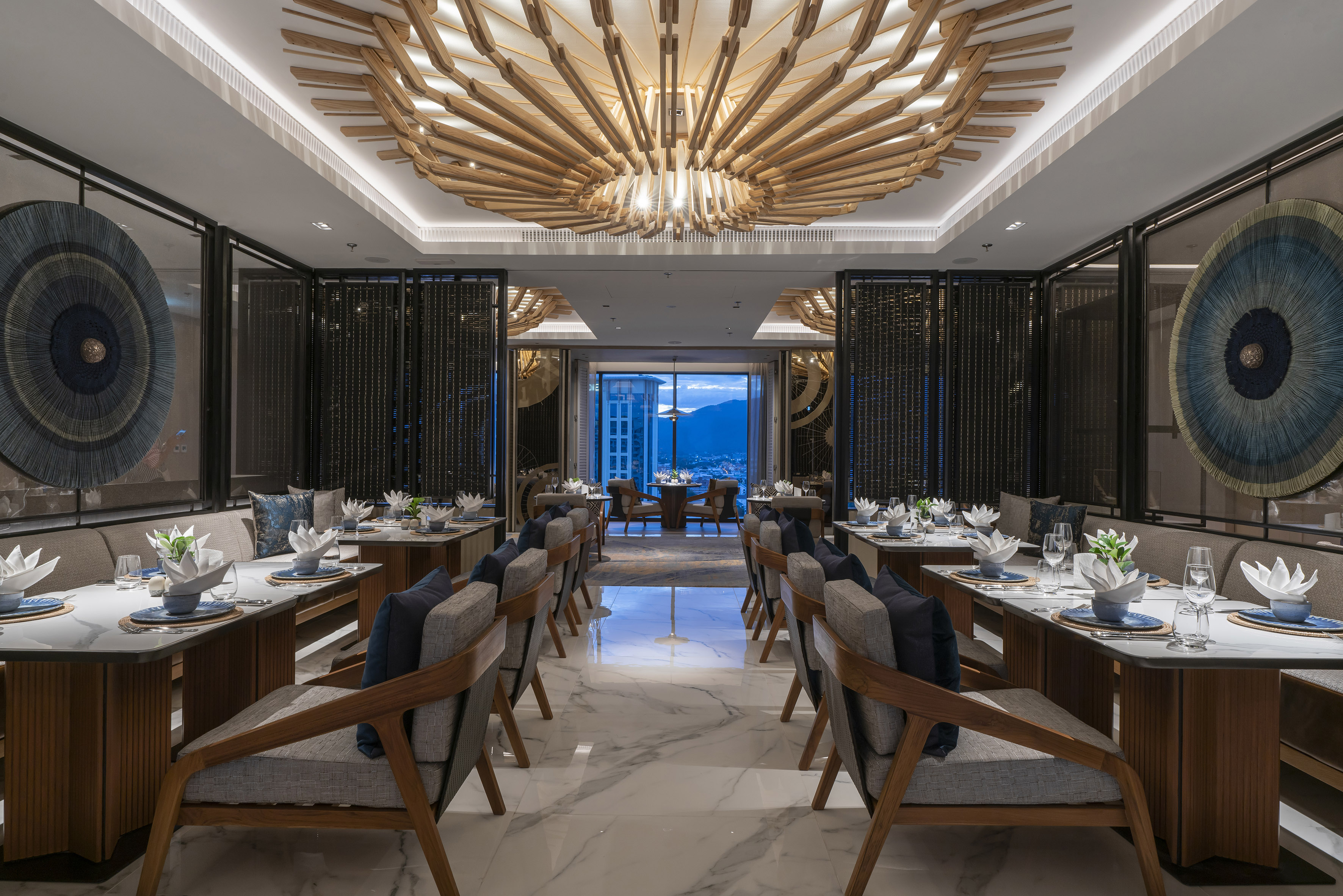 Modern luxury dining room with wooden ceiling, set tables, and city view.
