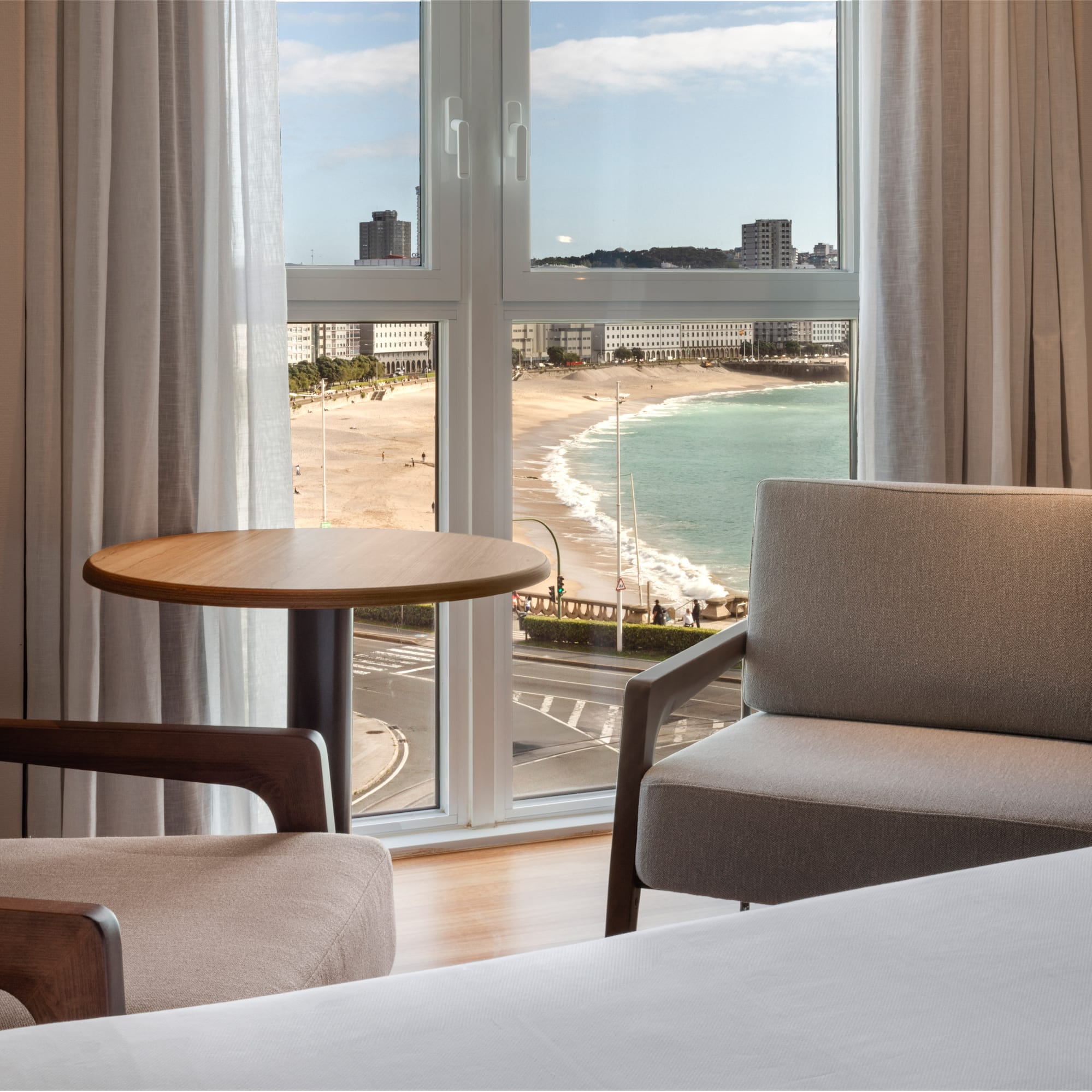 a room with a view of the beach and a table