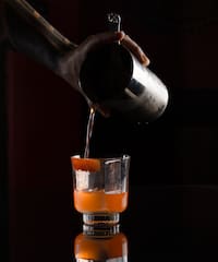 a person pouring liquid into a glass