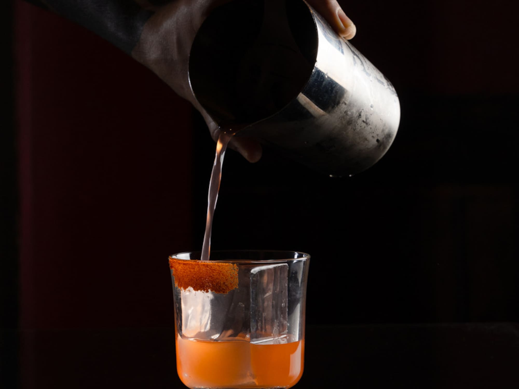 a person pouring liquid into a glass