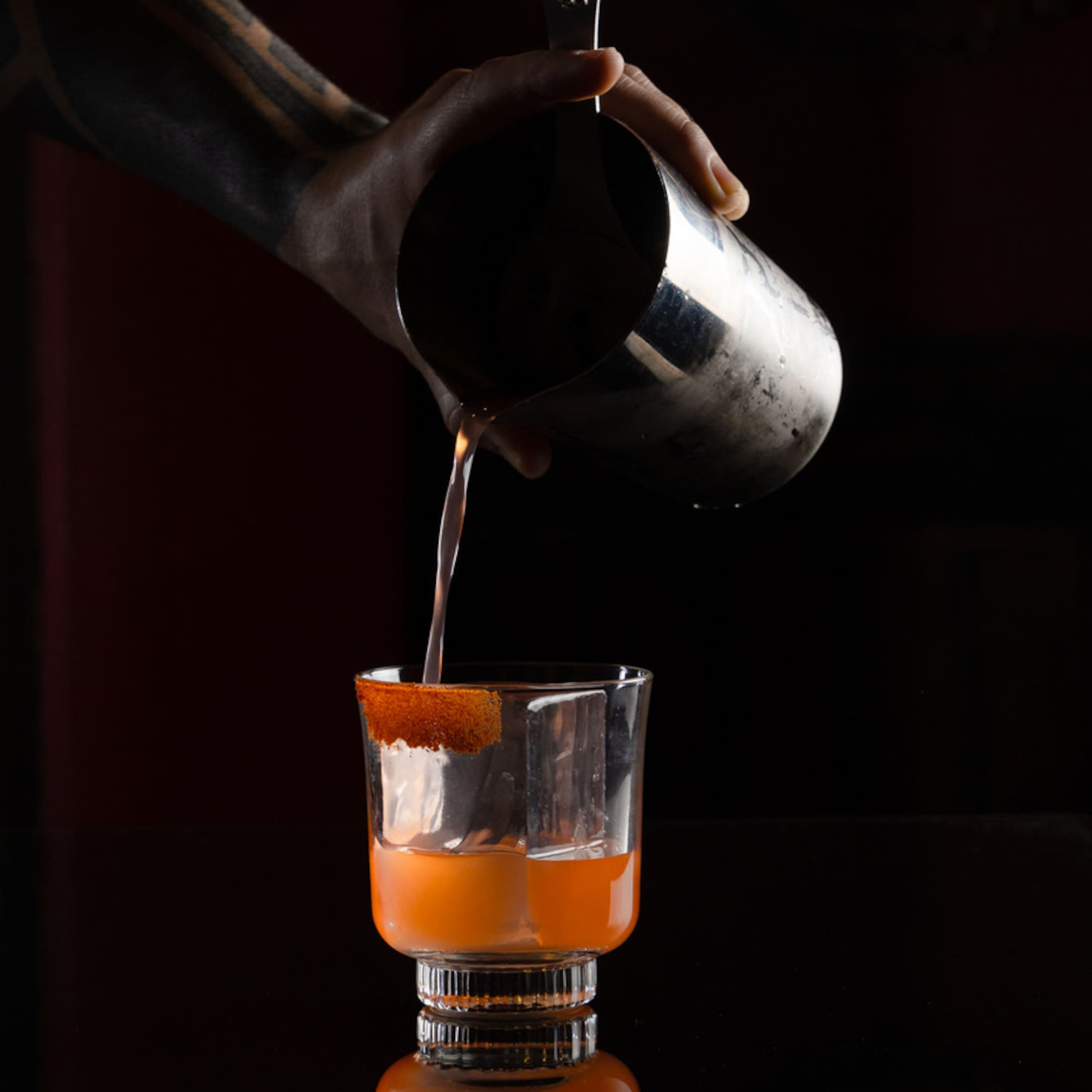 a person pouring liquid into a glass
