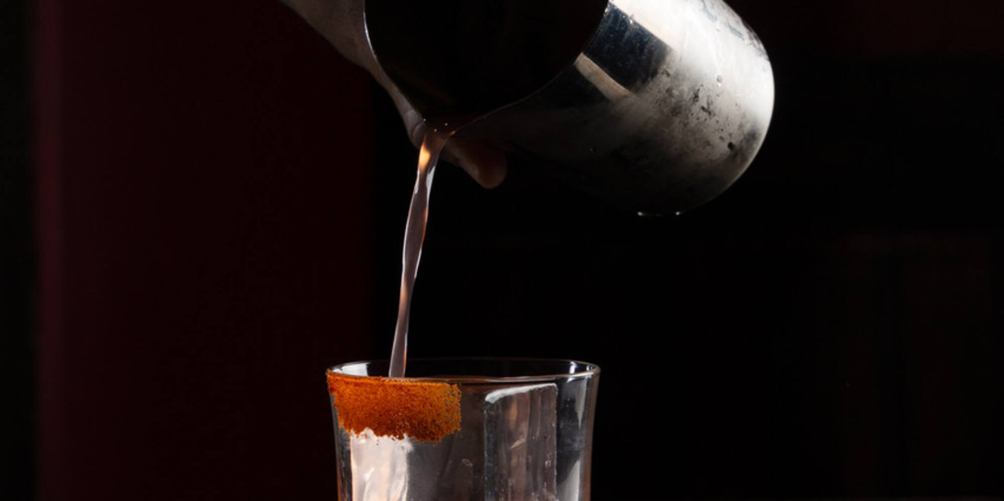a person pouring liquid into a glass