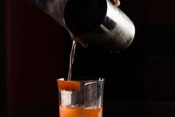 a person pouring liquid into a glass