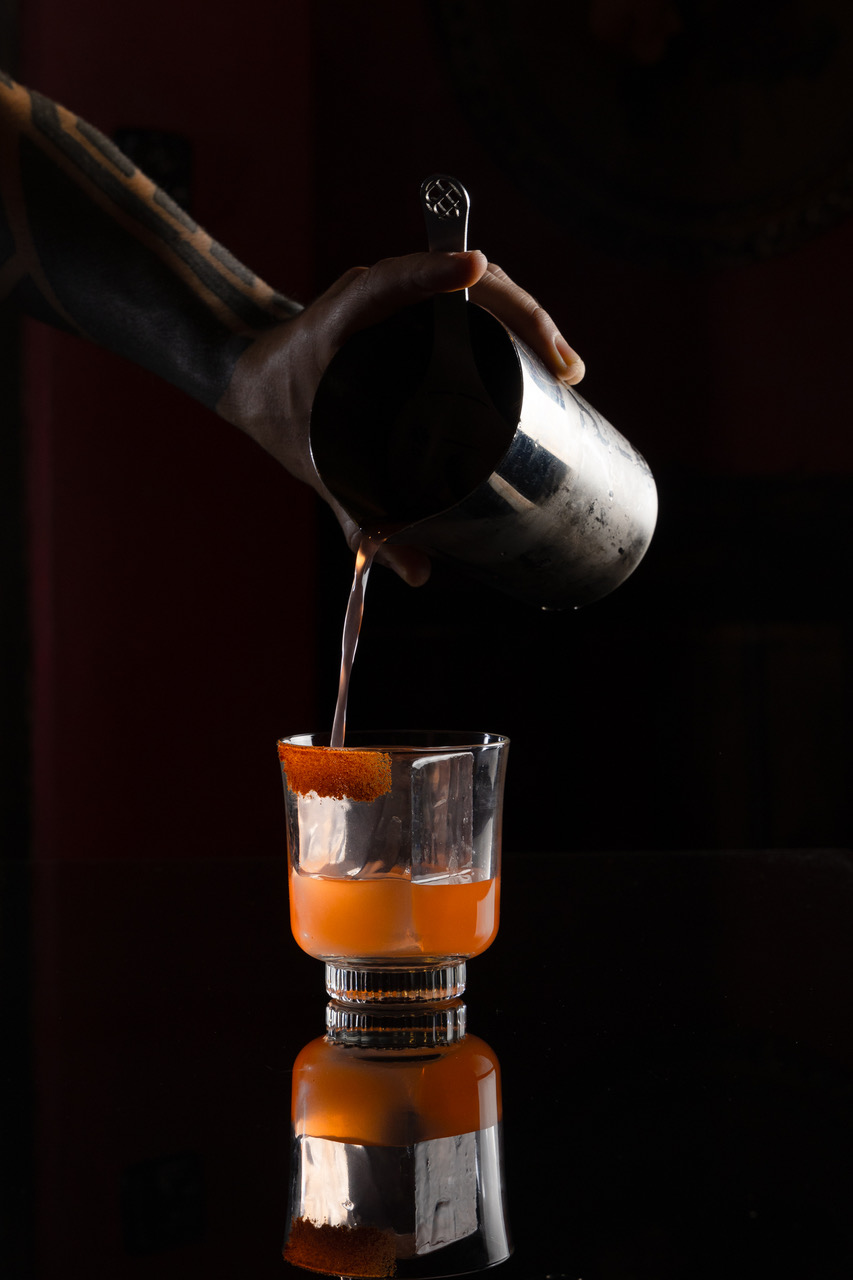 a person pouring liquid into a glass