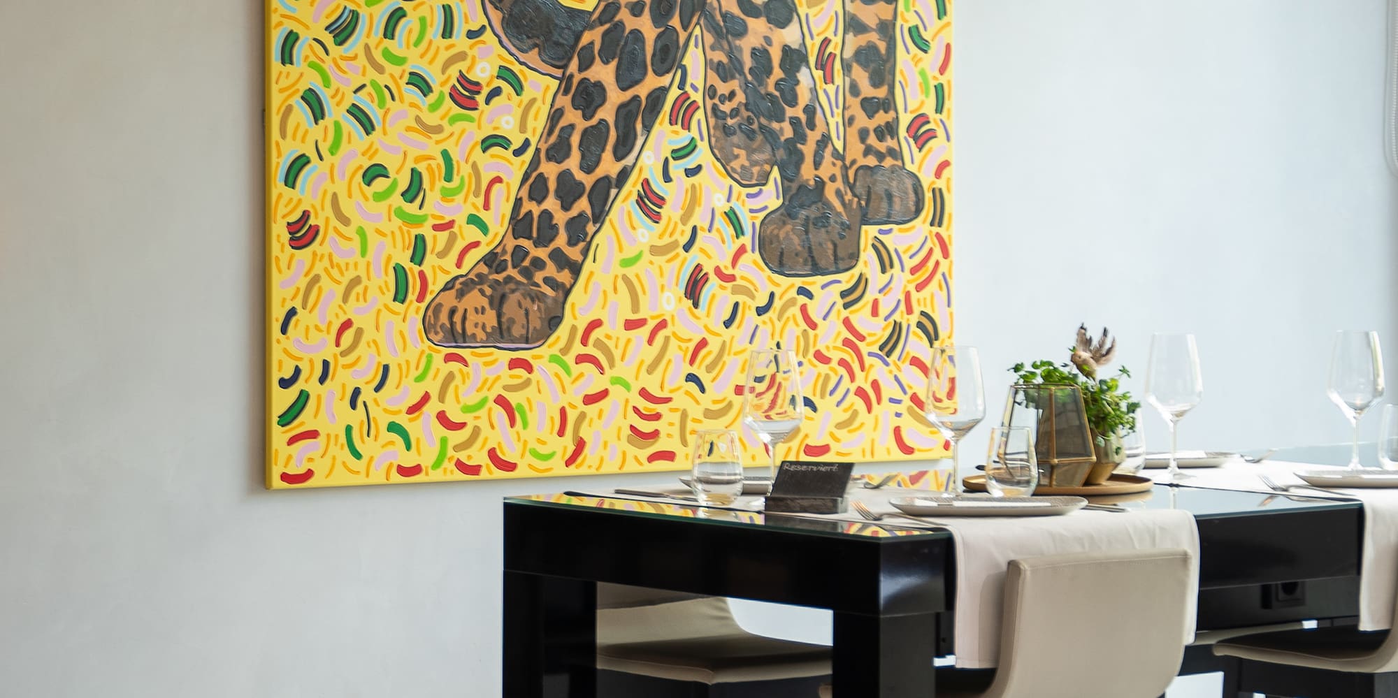 a table with chairs and a painting on the wall