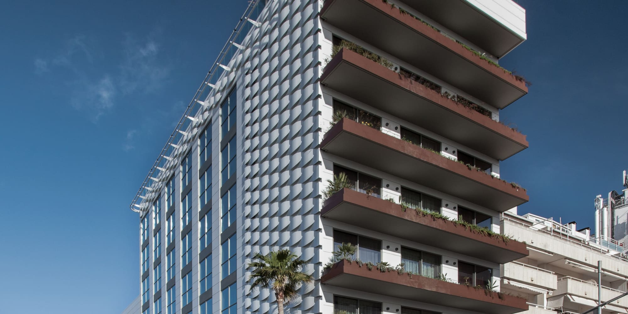 a building with balconies and palm trees