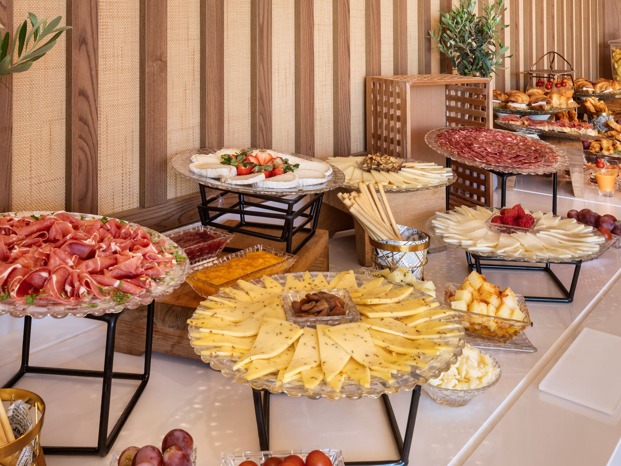 Breakfast buffet: prosciutto, salami, assorted cheeses, fruits, and pastries.