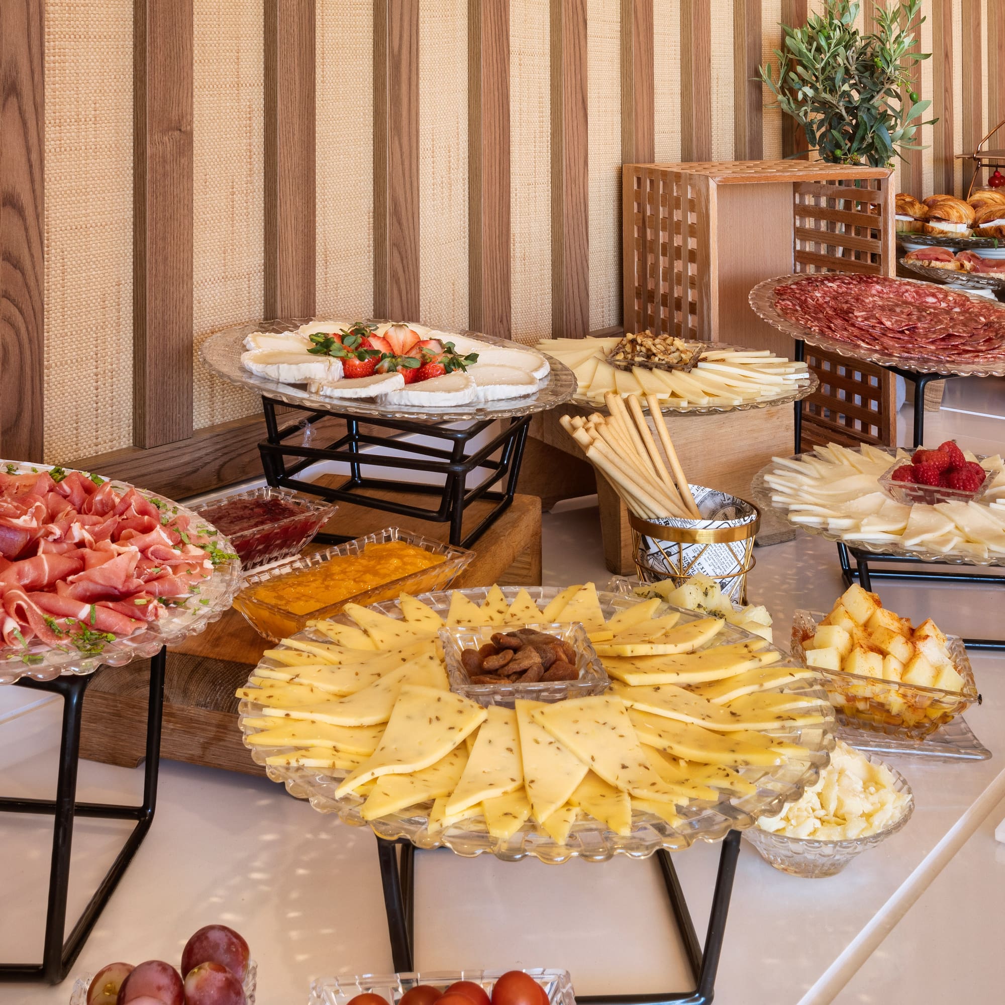 Hotel breakfast buffet with charcuterie, assorted cheeses, pastries, and fruit.