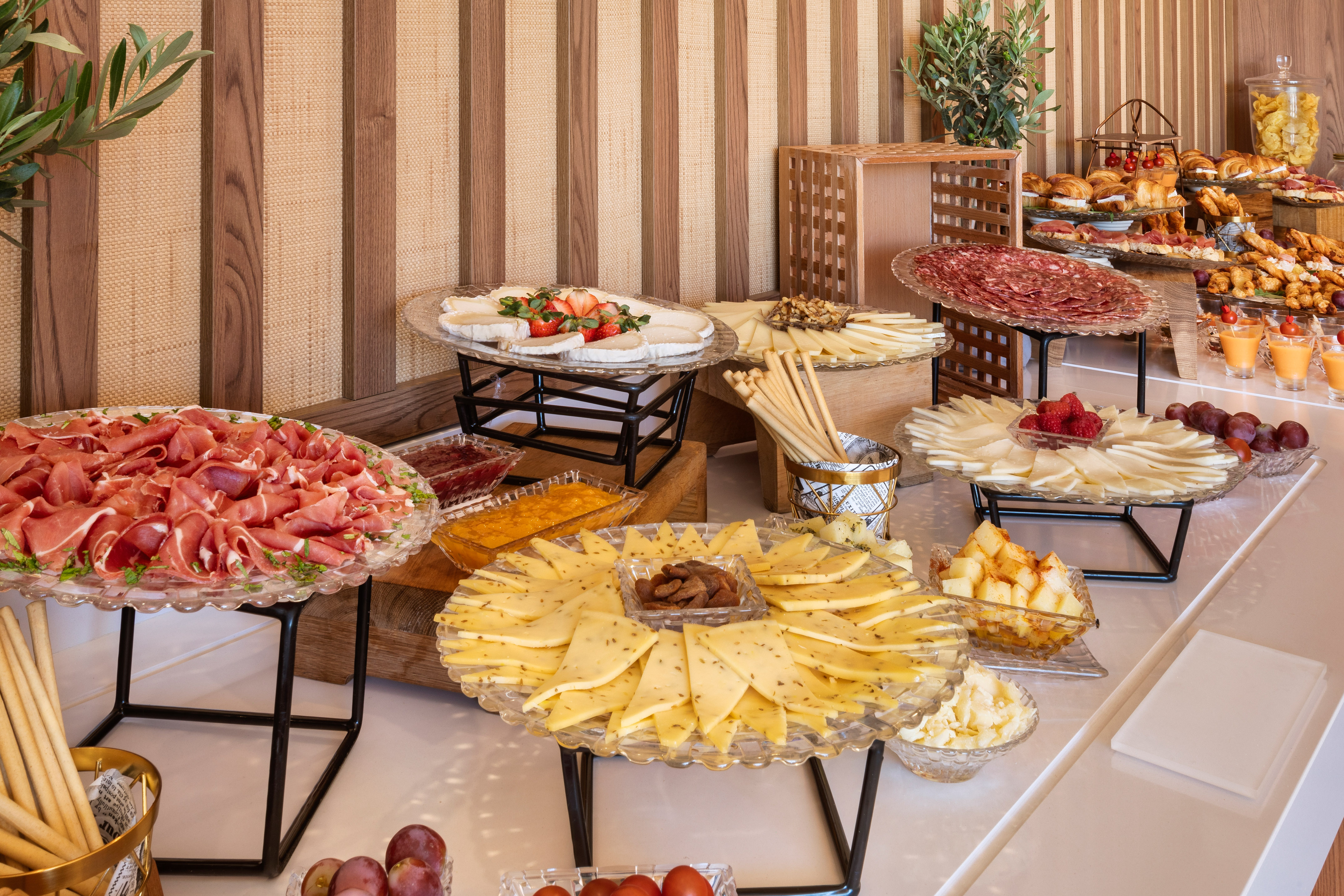 Breakfast buffet: prosciutto, salami, assorted cheeses, fruits, and pastries.