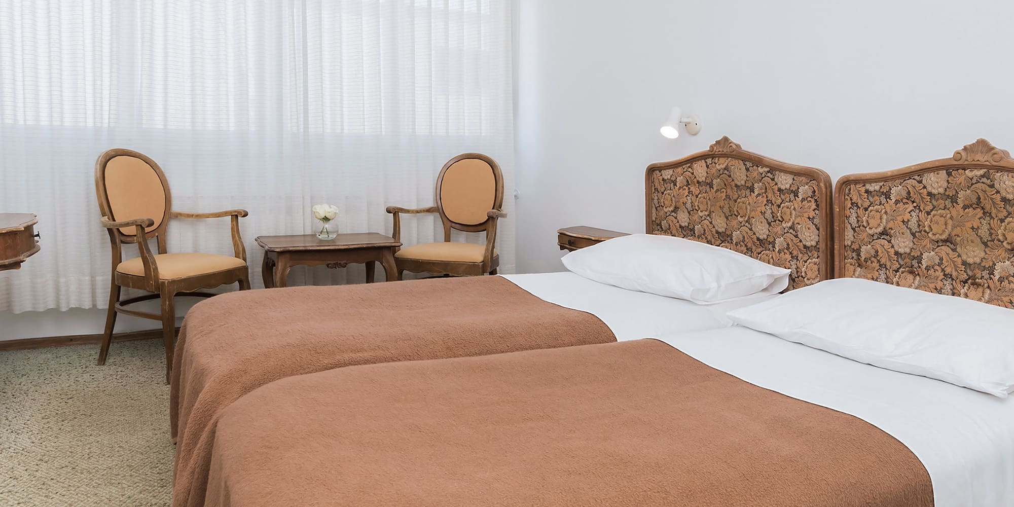 a room with two beds and chairs