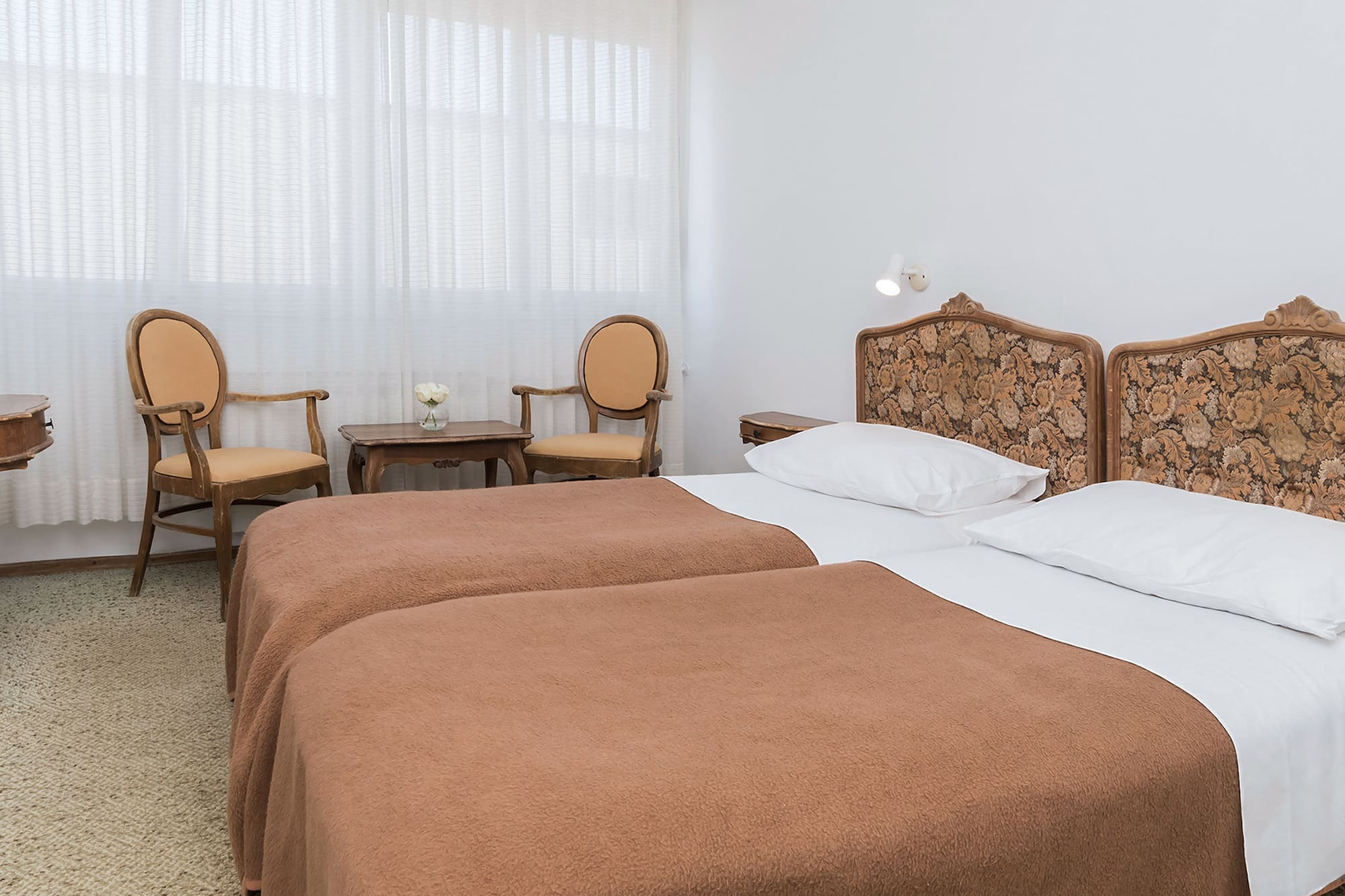 a room with two beds and chairs