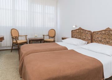 a room with two beds and chairs