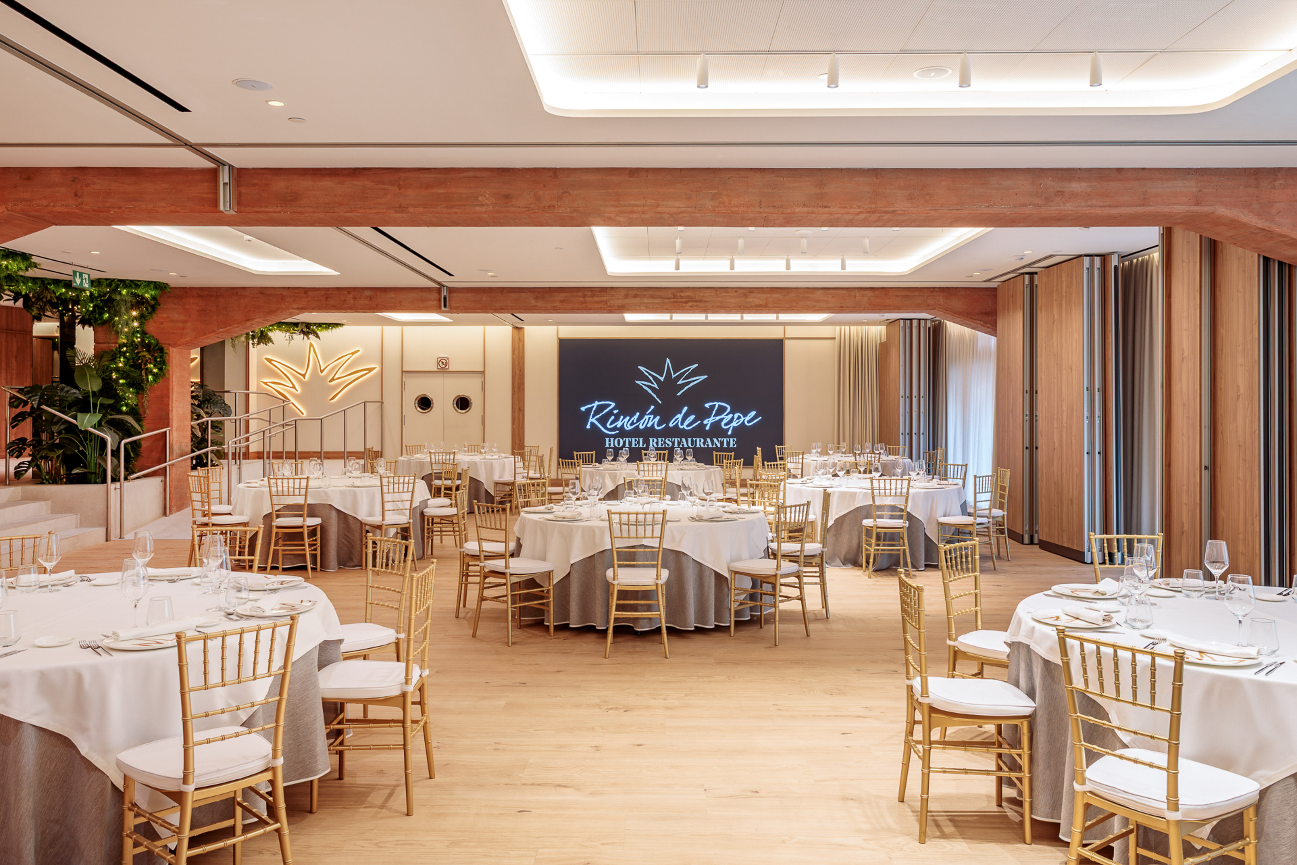 Rincón de Pepe hotel restaurant banquet hall with set tables and gold chairs.