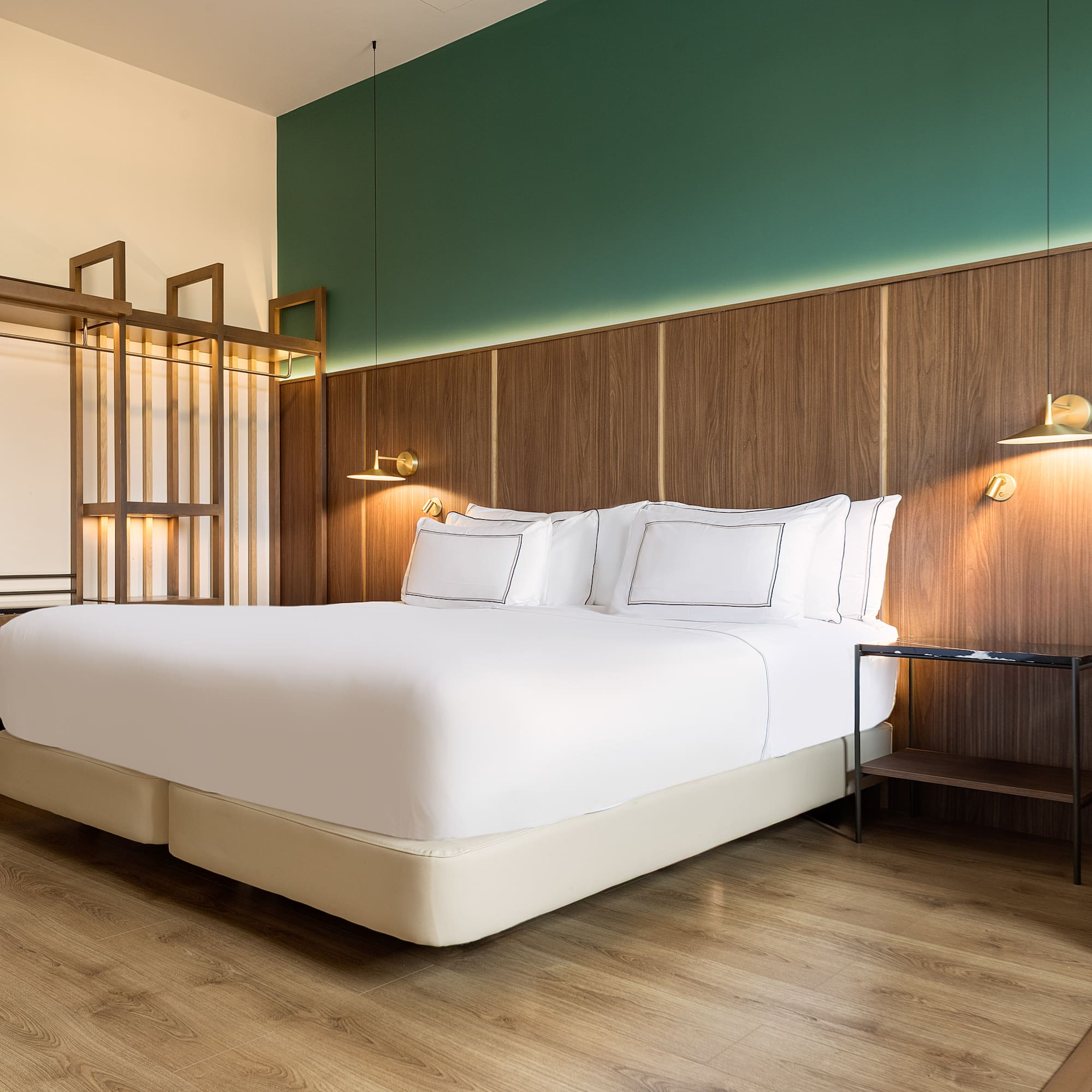 a bed with white sheets and a wood floor