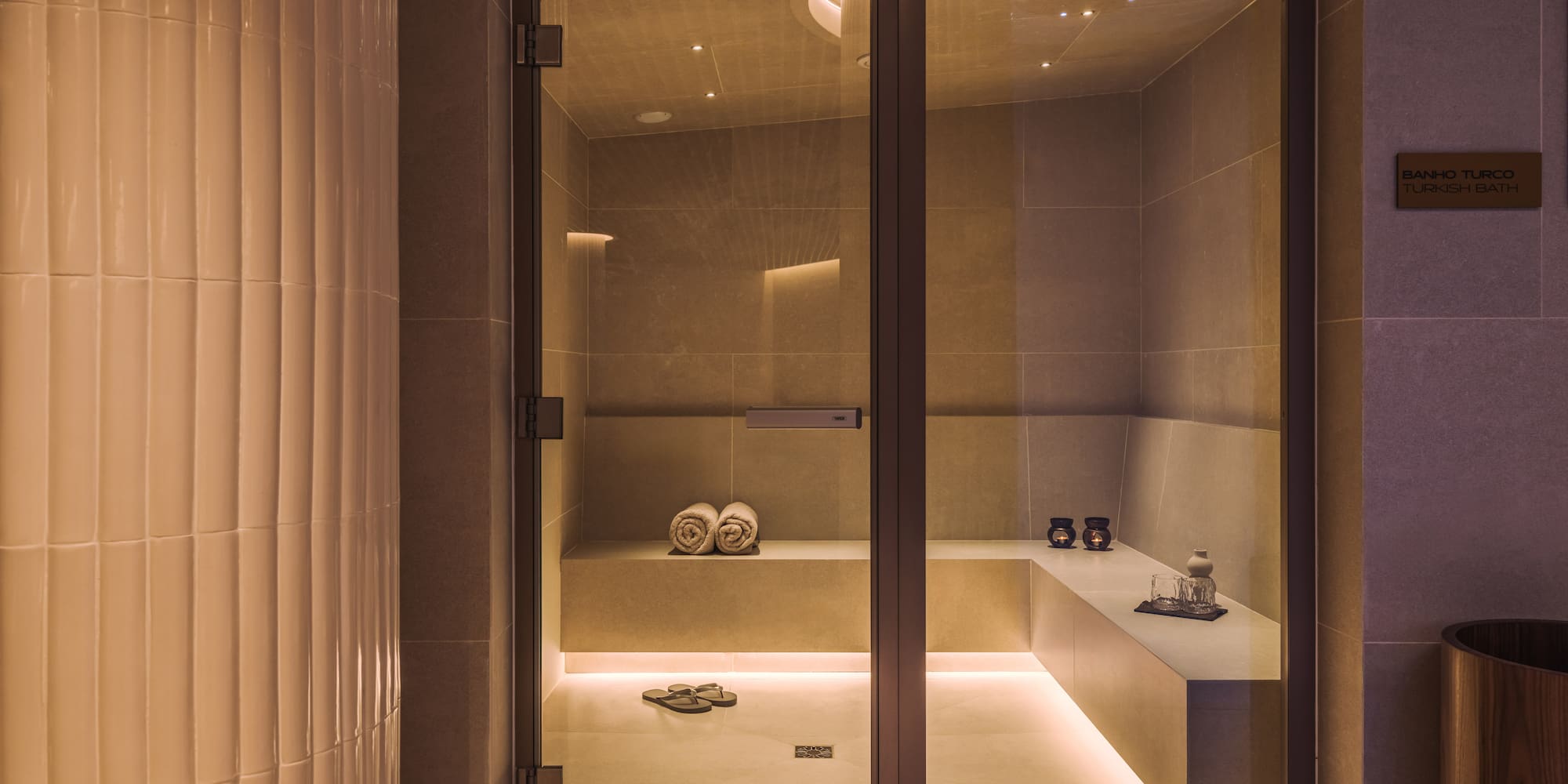 a glass door with a bench and towels in it