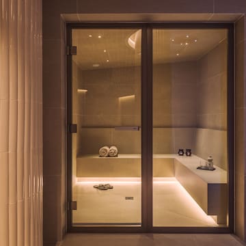 a glass door with a bench and towels in it