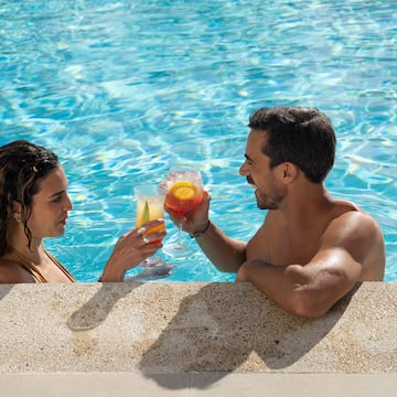 a man and woman in a pool with drinks