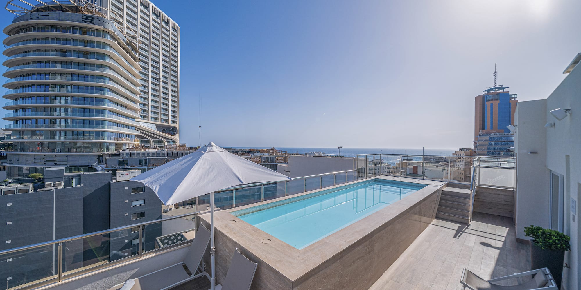 a pool on a rooftop overlooking a city