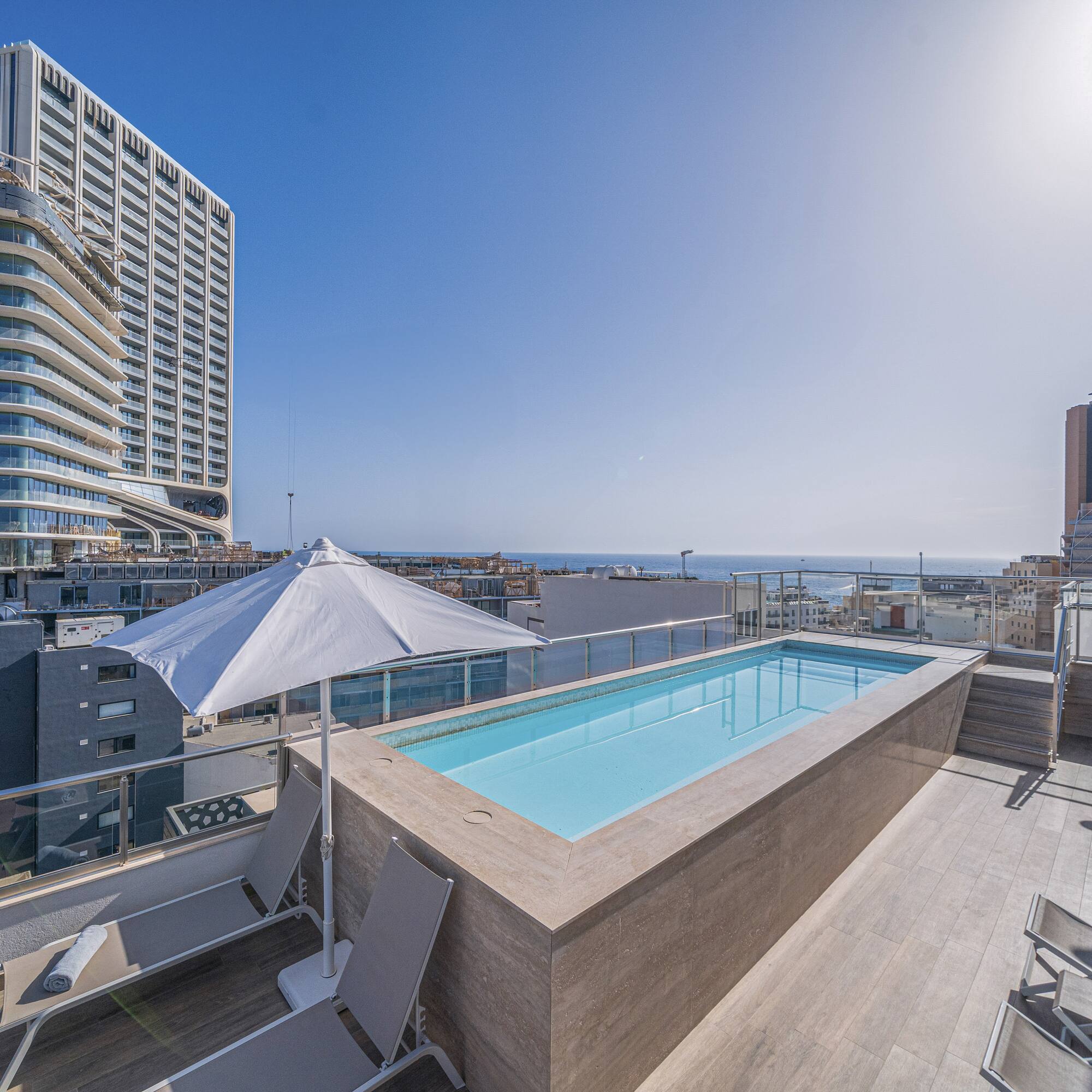a pool on a rooftop overlooking a city