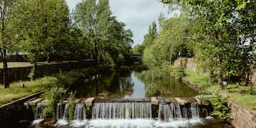 a river with a waterfall and trees