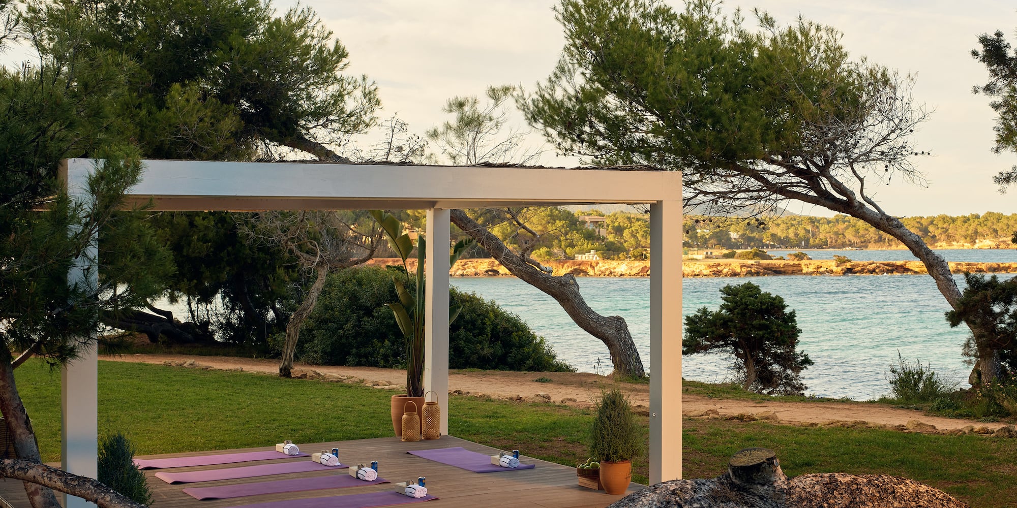 yoga mats on a deck near a body of water