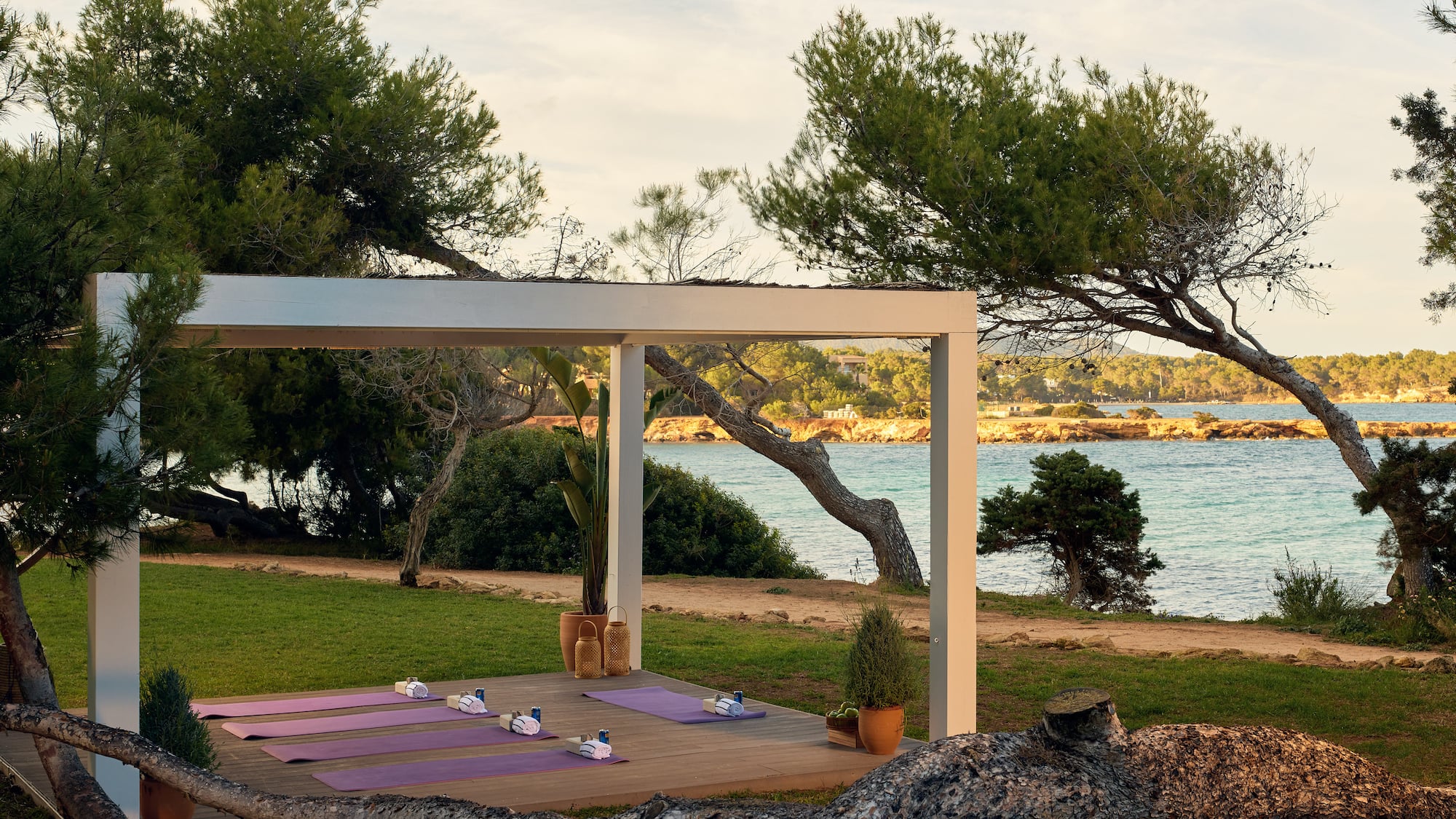 yoga mats on a deck near a body of water