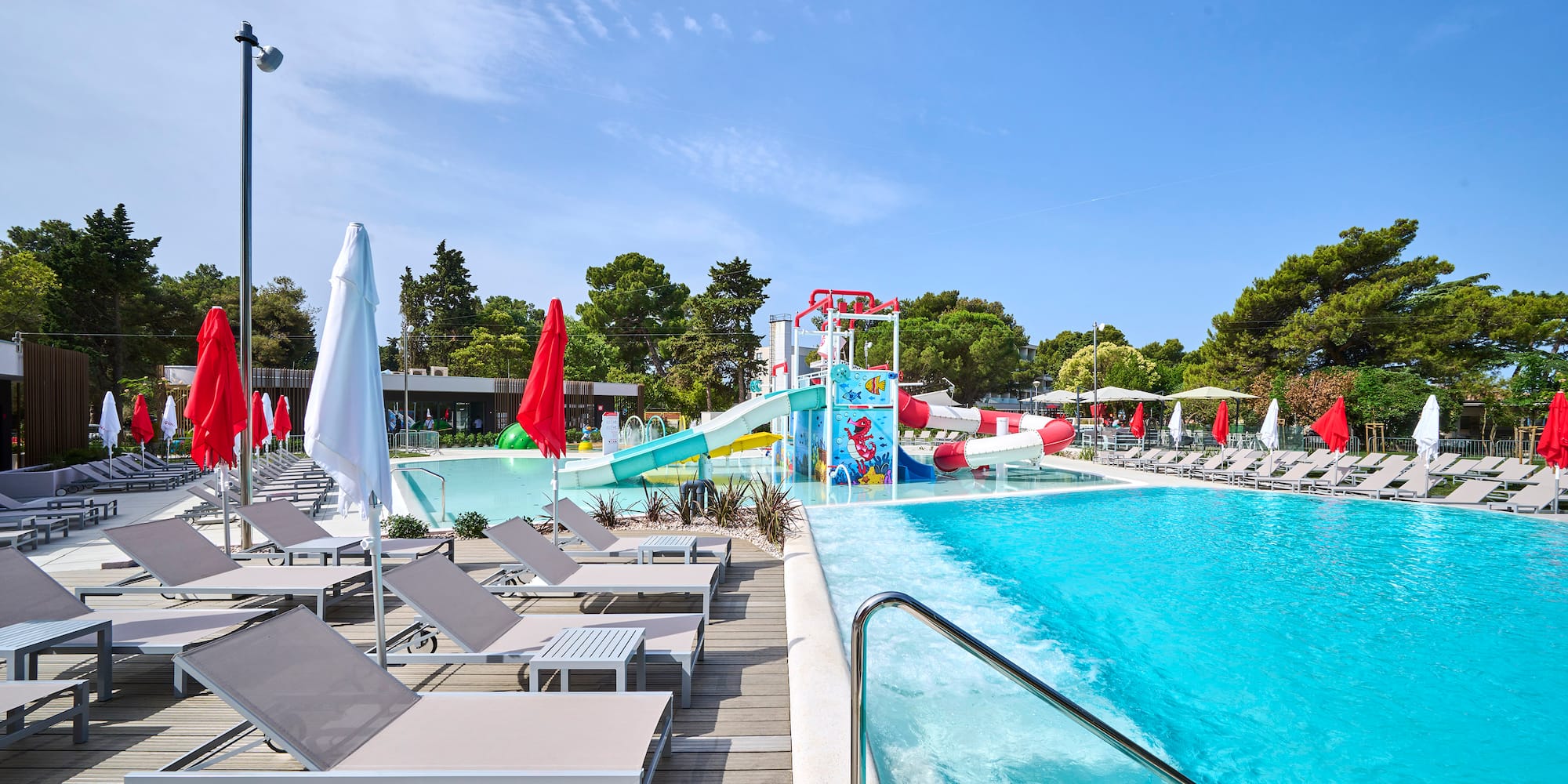 a pool with chairs and a slide