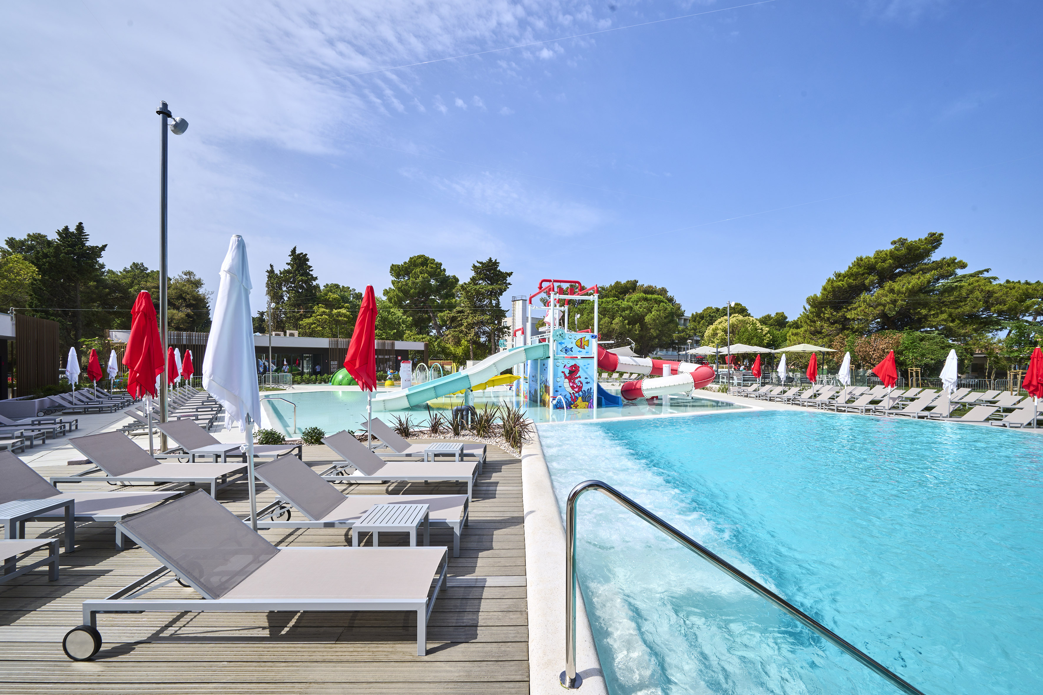 a pool with chairs and a slide