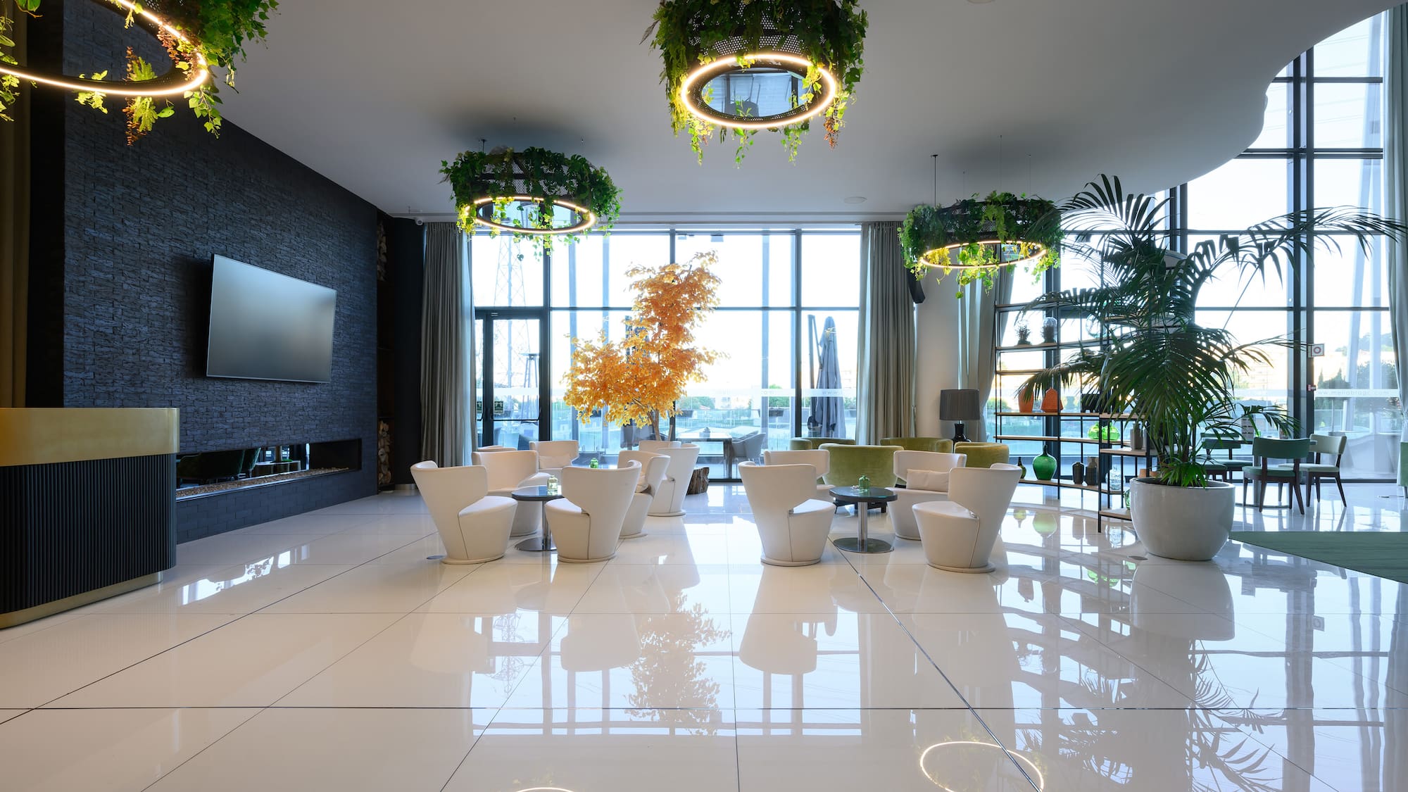 a room with white chairs and a television