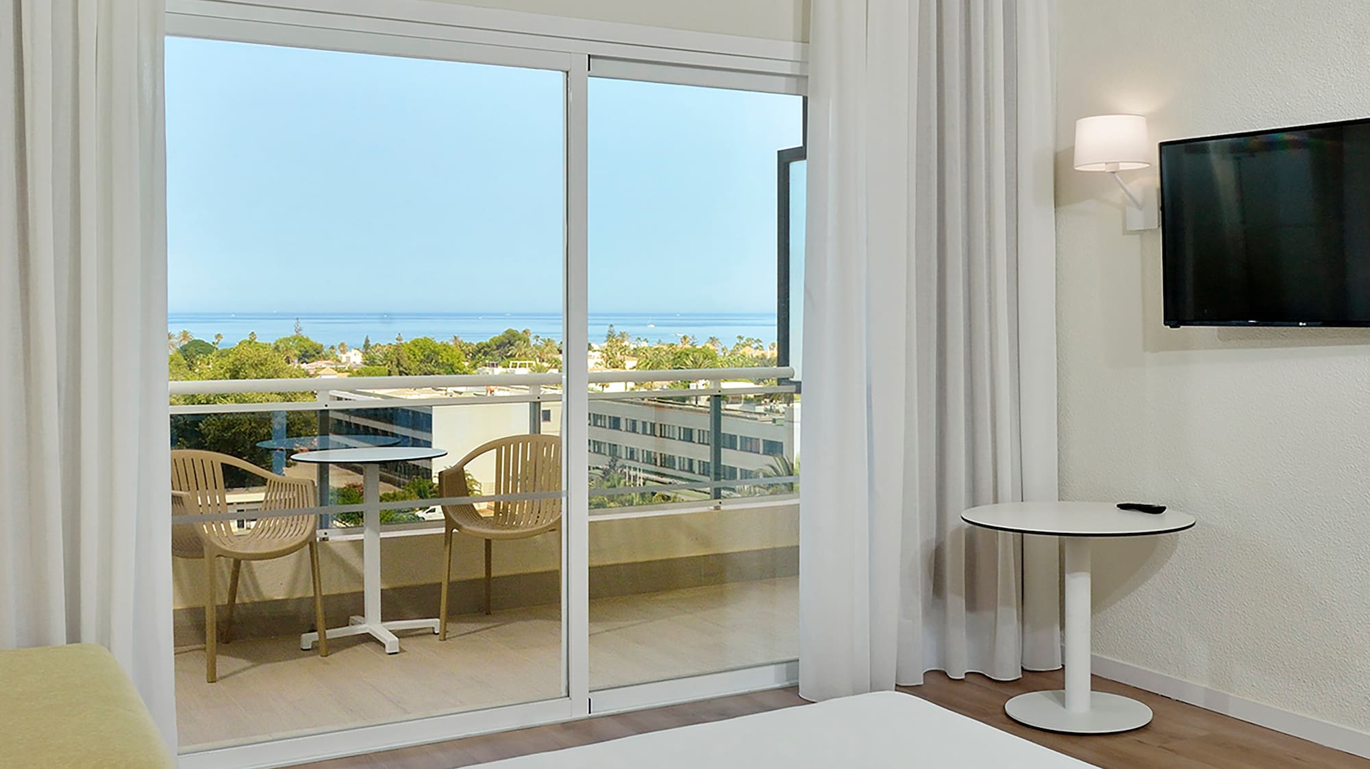 a room with a television and a view of the ocean