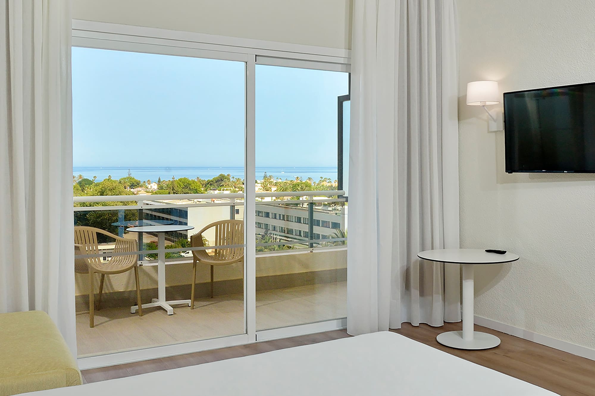 a room with a television and a view of the ocean
