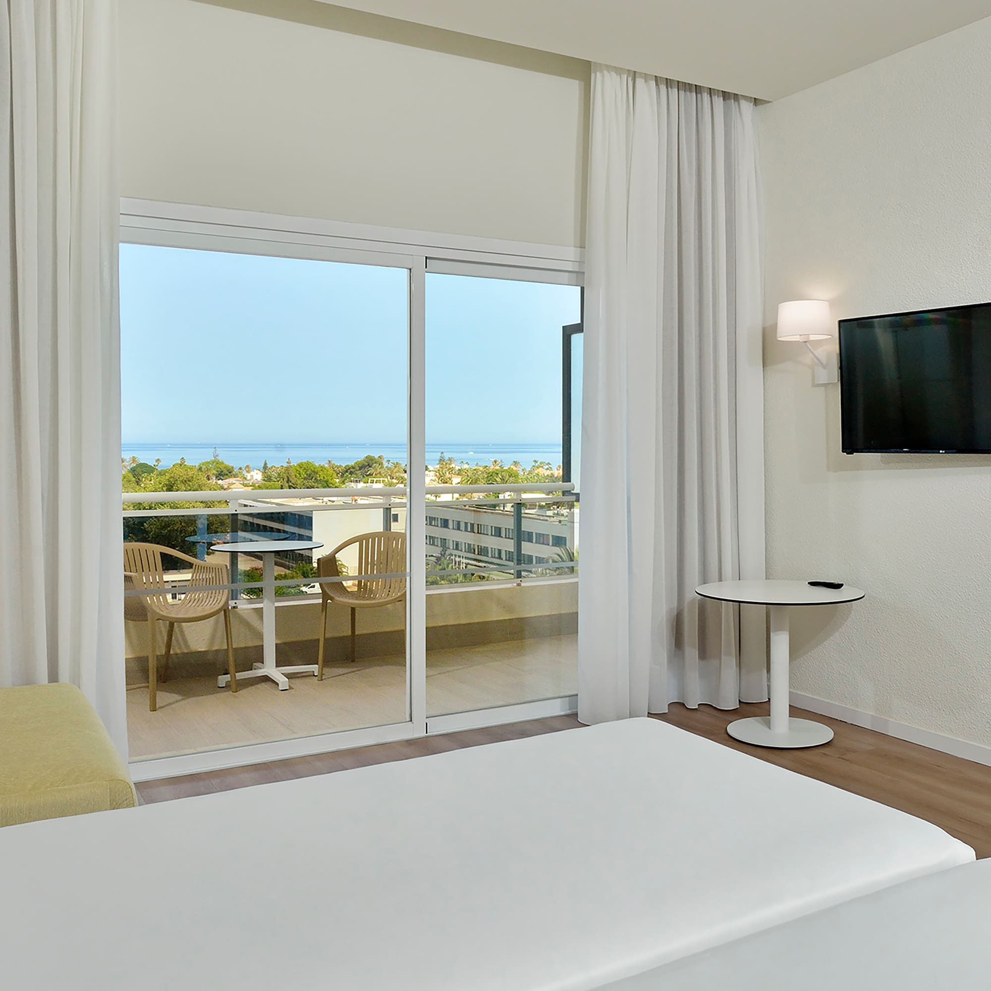 a room with a television and a view of the ocean