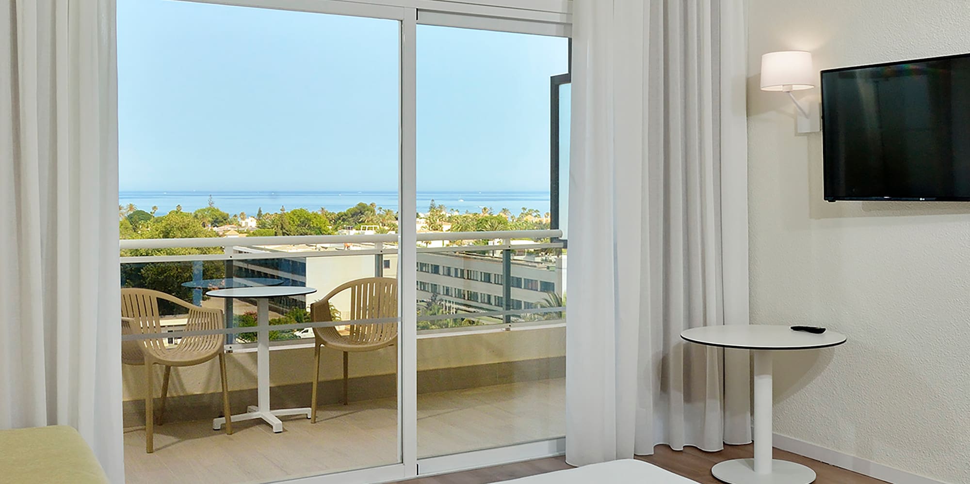 a room with a television and a view of the ocean