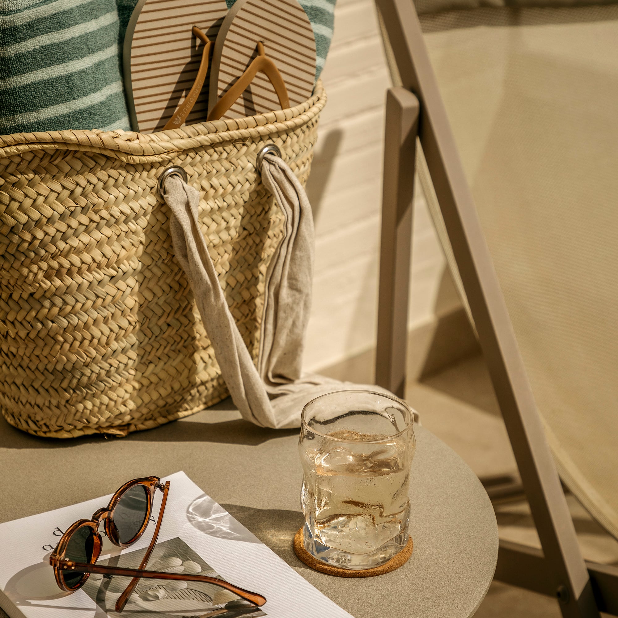 a bag with flip flops and sunglasses on a table