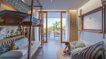 a boy playing in a room with bunk beds