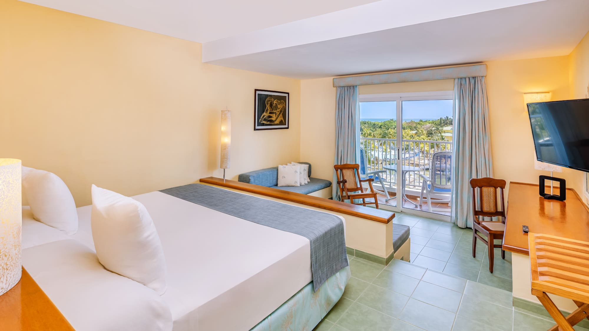 a room with a bed and chairs and a balcony