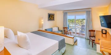 a room with a bed and chairs and a balcony