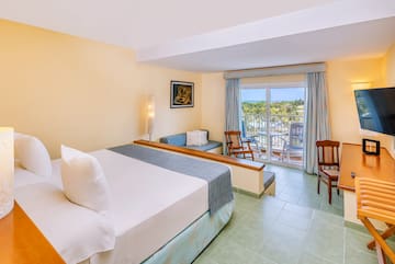 a room with a bed and chairs and a balcony