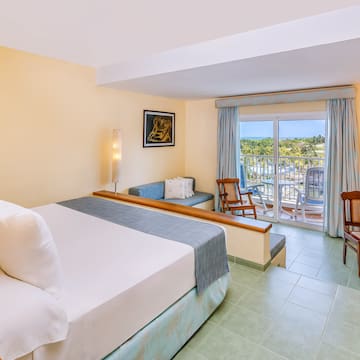 a room with a bed and chairs and a balcony