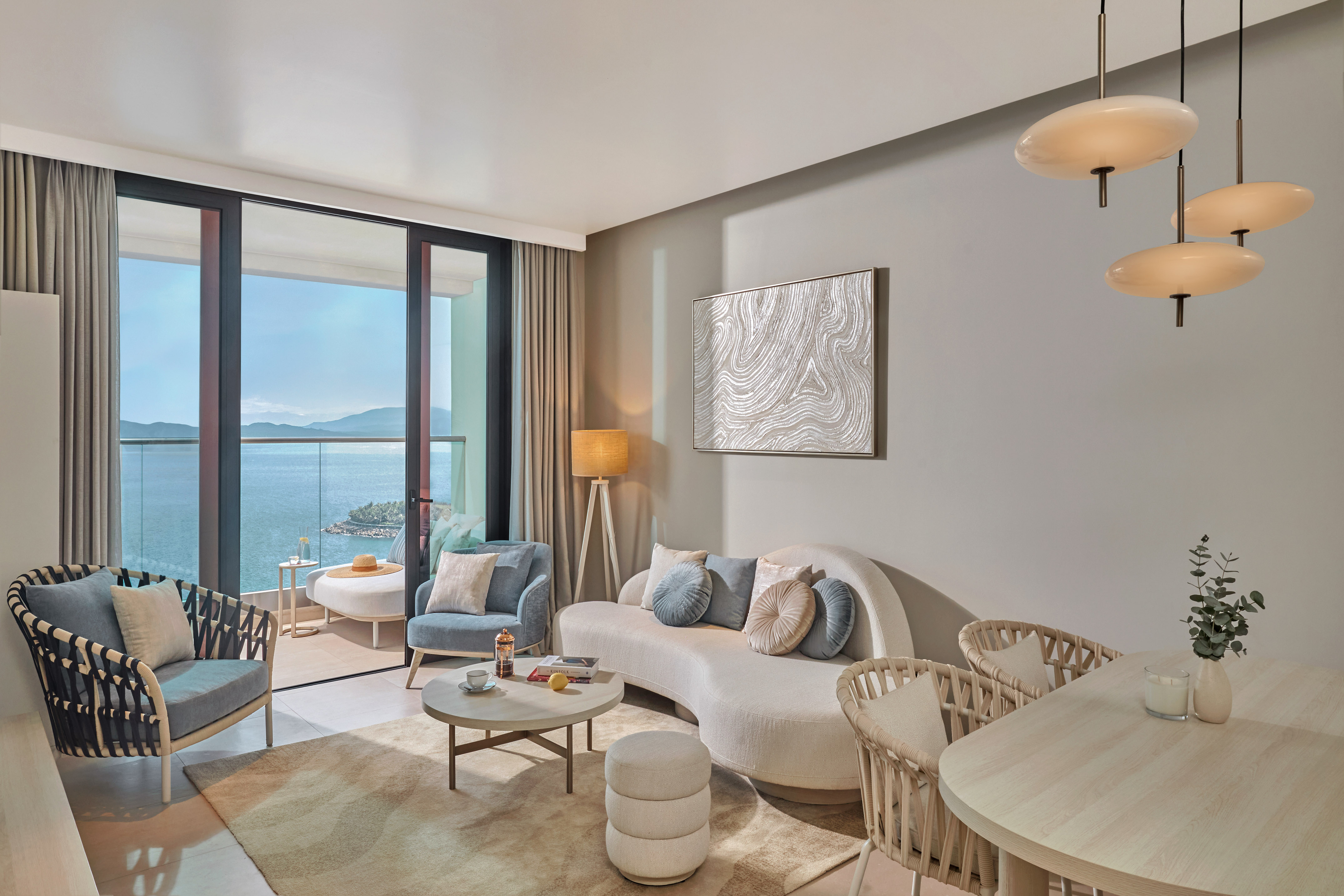 Elegant living room with sea view balcony, curved sofa, and modern interior.