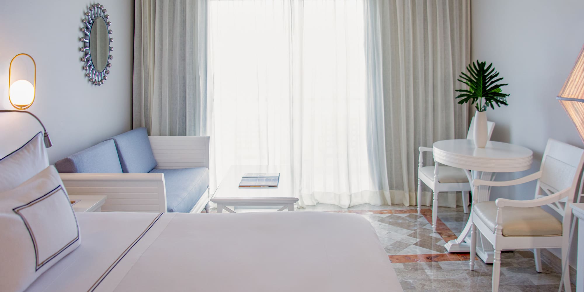 a room with a bed and a table and chairs