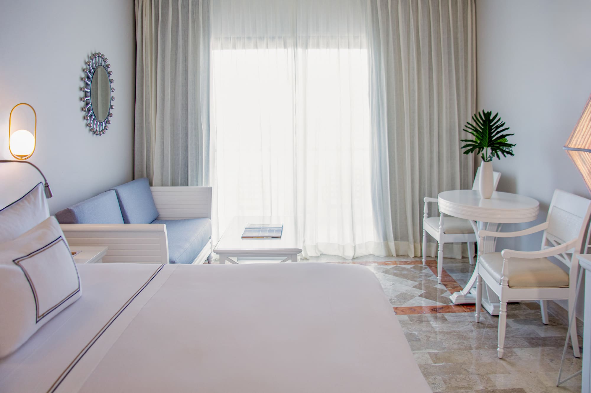 a room with a bed and a table and chairs