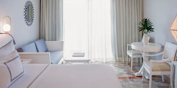 a room with a bed and a table and chairs